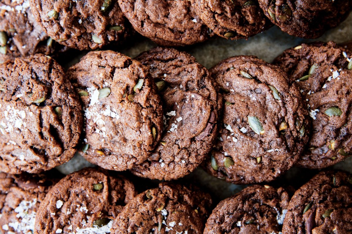 a tray of chocolate flavored cookies with nuts and pumpkin seeds