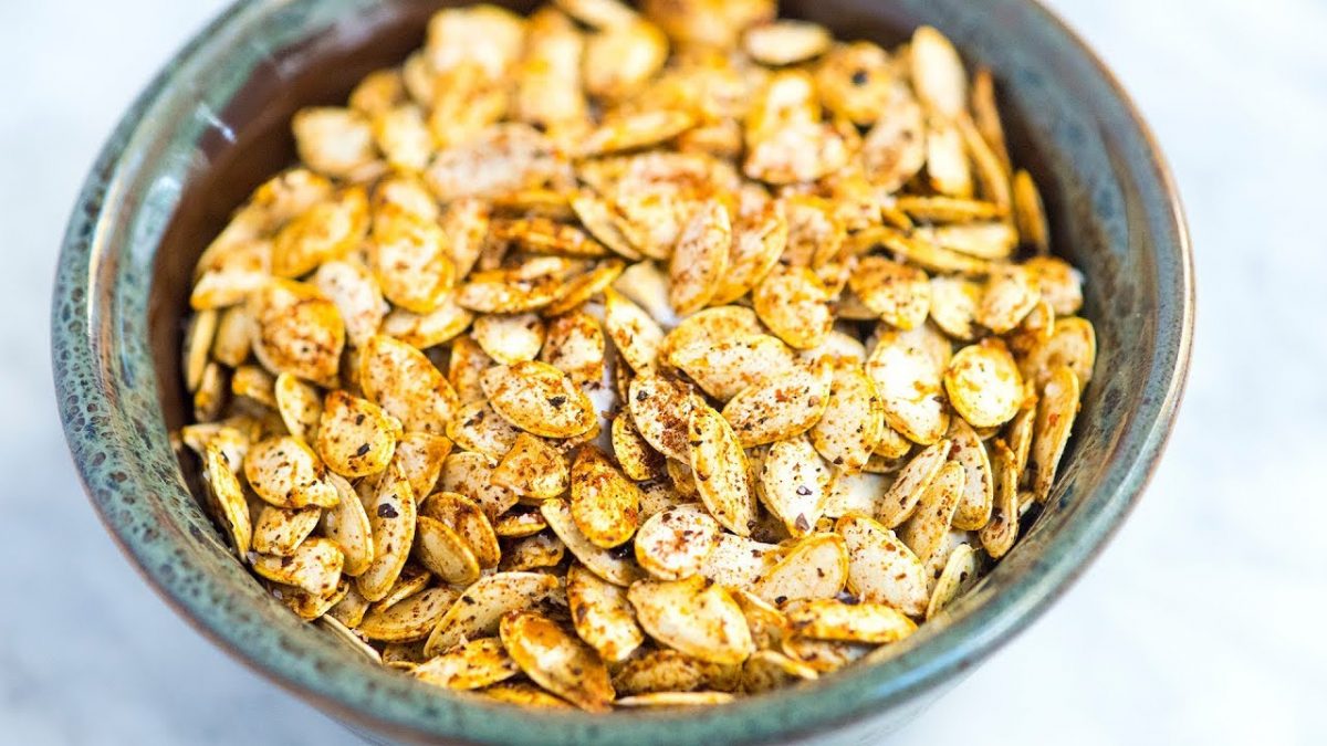 a bowl of roasted pumpkin seeds drizzled with spices